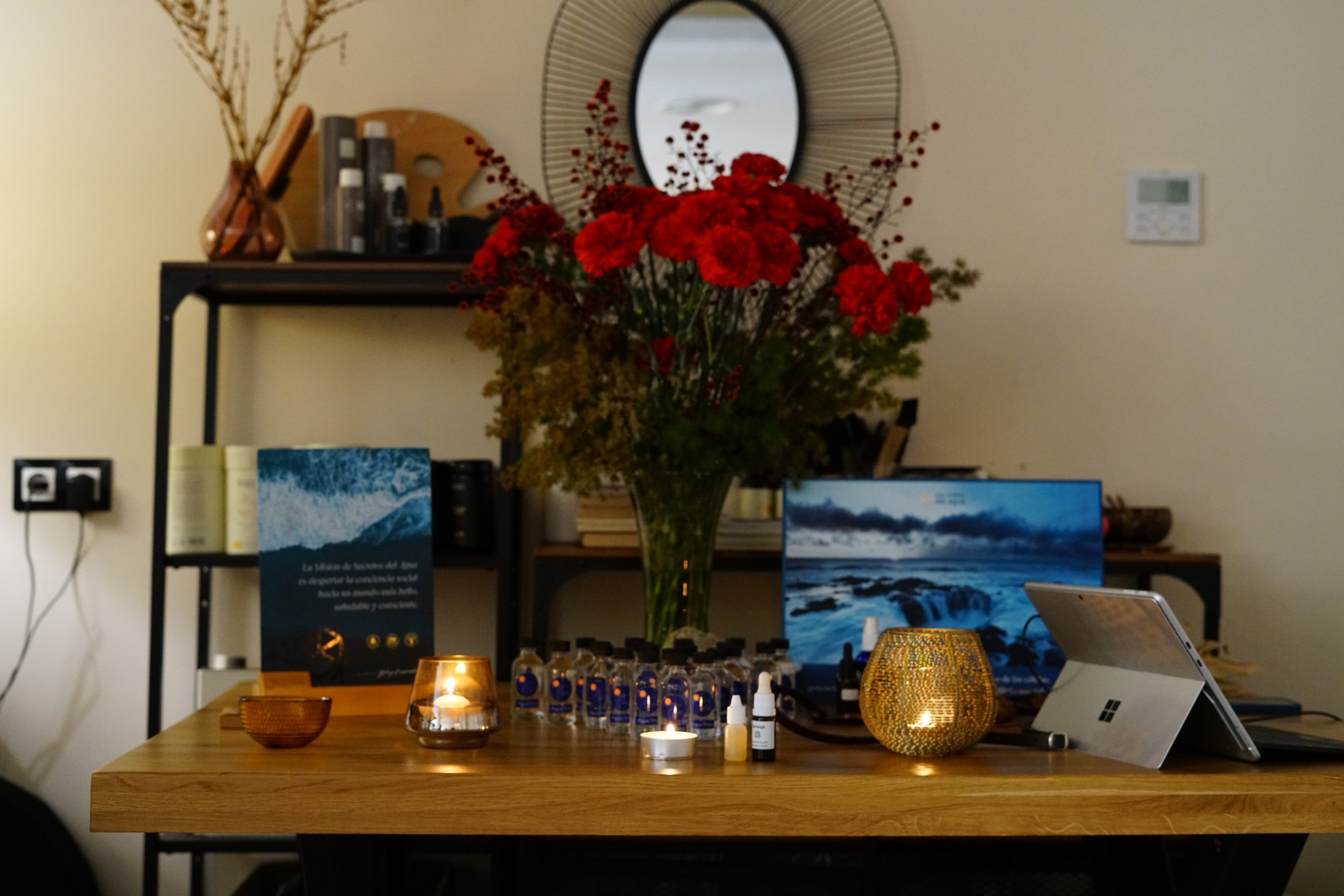 Mesa decorada con velas encendidas, esencias florales, flores frescas y material terapéutico en un entorno cálido y armonioso; ambiente relajante en Caminar Creciendo, Sevilla, ideal para sesiones de desarrollo personal y bienestar.
